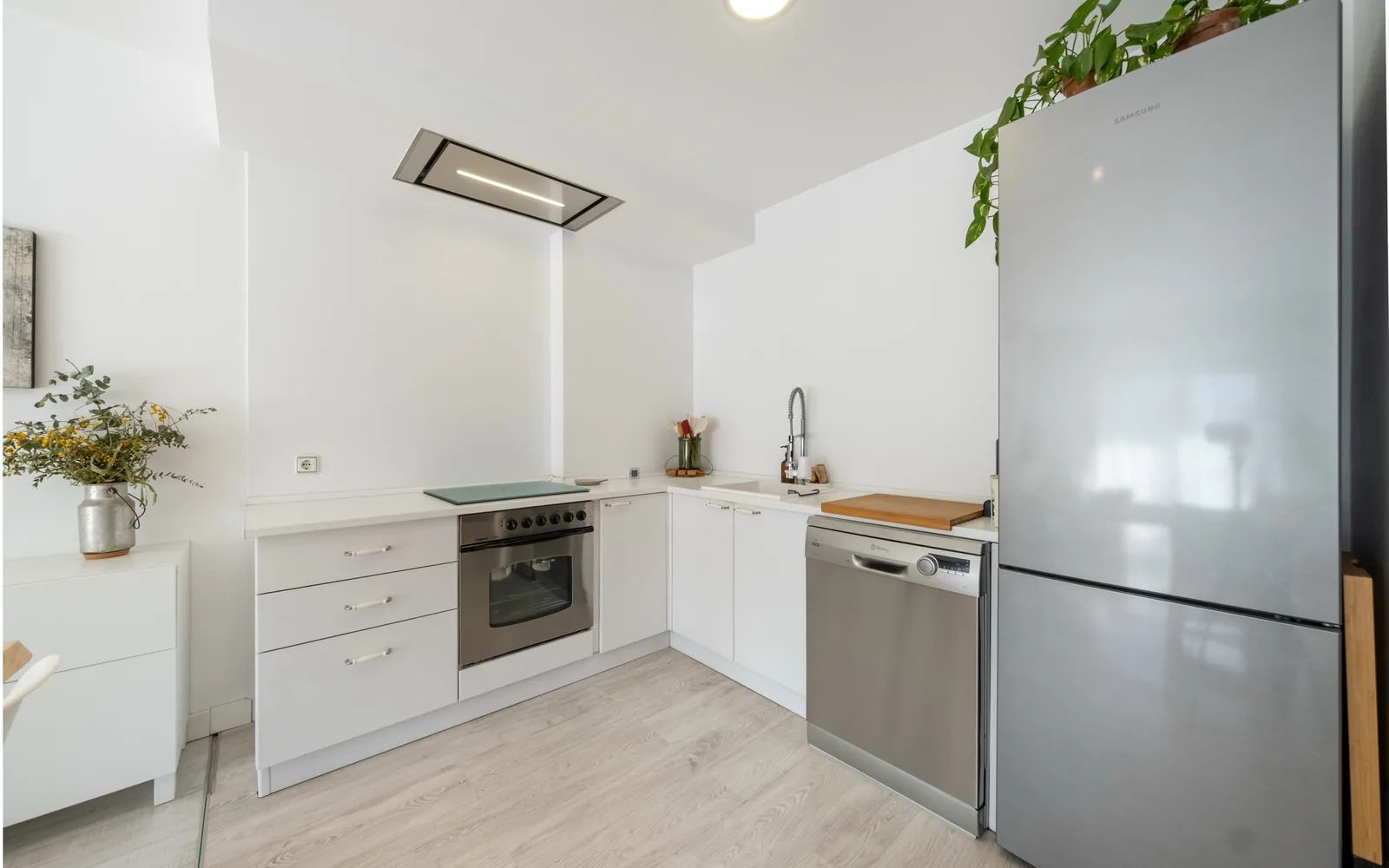 Bright kitchen with a stainless dishwasher, oven and refrigerator