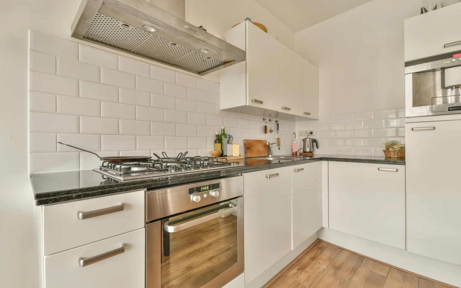 White kitchen cabinets and drawers under a subway tile backsplash